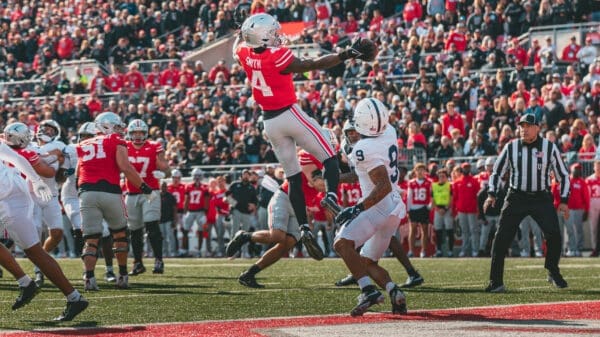 Jeremiah Smith leaps and stretches over a Penn State defender to make a one handed touchdown catch.